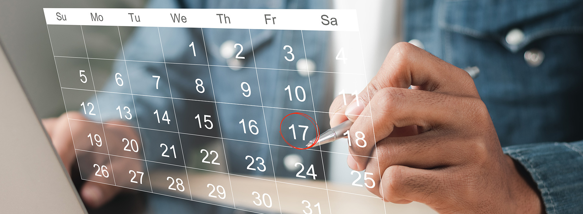 The image shows a person holding a tablet displaying a calendar with a pen marking an event, suggesting planning or scheduling activities.