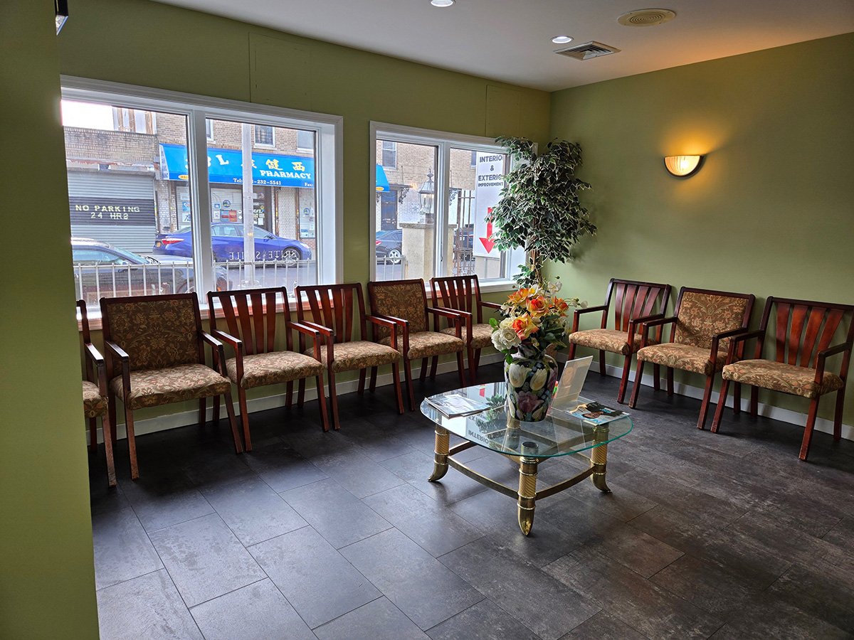 The image depicts an interior space with a row of wooden chairs against a wall, arranged in front of a window.